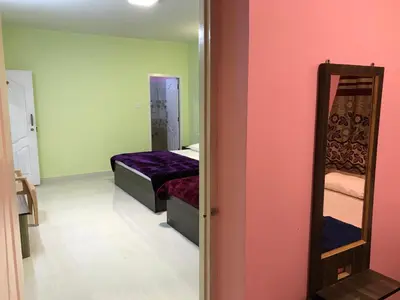 a small bedroom with a bed and a mirror at HAPPYSTAY rooms and cottages in Ooty