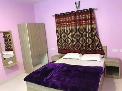 a bedroom with a bed with a curtain above it at HAPPYSTAY rooms and cottages in Ooty