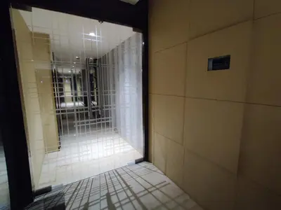 a hallway with a shower with a glass door at Neermala Residency in Coimbatore