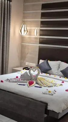 a bed with two swans decorations on it at Neermala Residency in Coimbatore