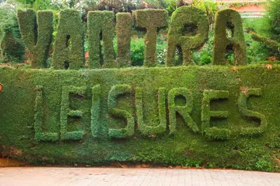 a sign covered in green moss on a hedge at Yantra Resort, Ooty in Ooty