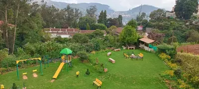 an aerial view of a park with a playground at Yantra Resort, Ooty in Ooty