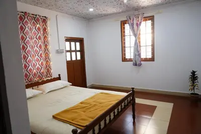 a bedroom with a bed with a blanket on it at Bison Valley Estate in Vālpārai