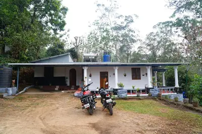 a motorcycle parked in front of a house at Bison Valley Estate in Vālpārai