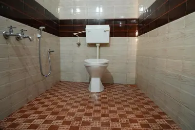 a bathroom with a toilet and a shower at Bison Valley Estate in Vālpārai
