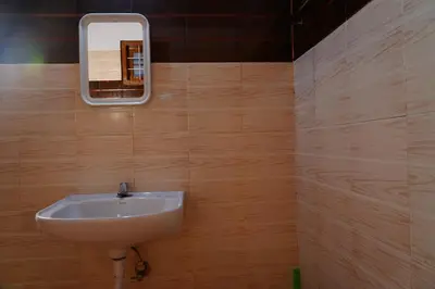 a bathroom with a sink and a mirror on the wall at Bison Valley Estate in Vālpārai