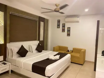 a bedroom with a large bed and a chair at THE PORCH INN in Wayanad