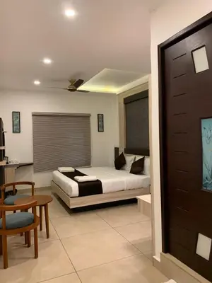 a bedroom with a bed and a table and a chair at THE PORCH INN in Wayanad