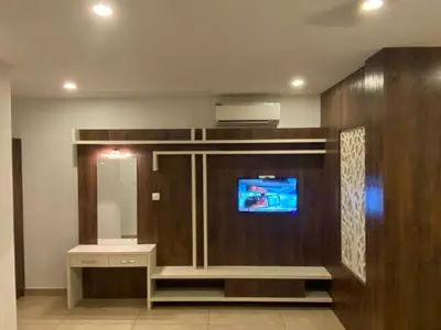 a bathroom with a tv and a vanity with a mirror at THE PORCH INN in Wayanad