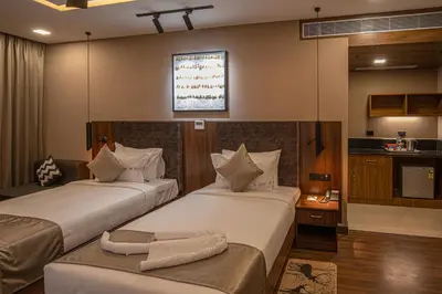 a hotel room with two beds and a kitchen at Windstone Residency in Coimbatore