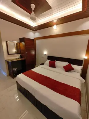 a bedroom with a large bed with red pillows at Coorg Nest Cottages By Dreamy Vacations in Kushālnagar