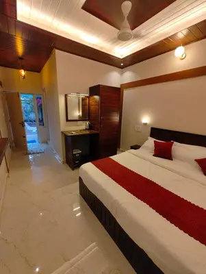 a bedroom with a large bed and a bathroom at Coorg Nest Cottages By Dreamy Vacations in Kushālnagar