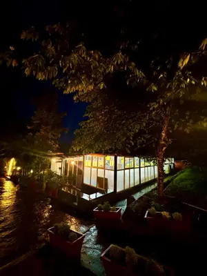 a building next to a river at night at Coorg Nest Cottages By Dreamy Vacations in Kushālnagar