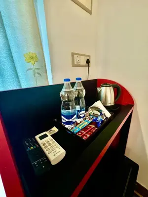 a table with two bottles of water and a remote control at Coorg Nest Cottages By Dreamy Vacations in Kushālnagar