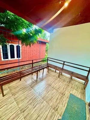 a wooden bench sitting on top of a balcony at Coorg Nest Cottages By Dreamy Vacations in Kushālnagar