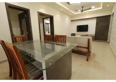 a dining room with a glass table and chairs at SR BOUTIQUEE STAY in Coimbatore
