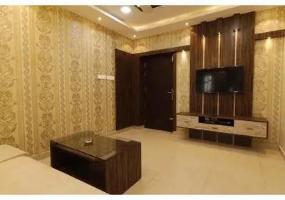 a living room with a couch and a tv on a wall at SR BOUTIQUEE STAY in Coimbatore