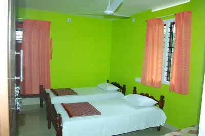 two beds in a green room with two windows at Birds Song Homestay - Thattekadu in Ernakulam