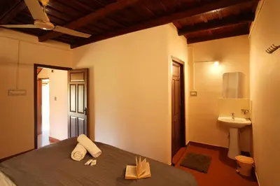 a bedroom with a bed and a sink in a room at Zostel Homes Wayanad, Thirunelly in Wayanad