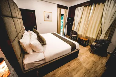 a bedroom with a bed with white sheets and pillows at VANYA by Citrine in Nelliyampathy