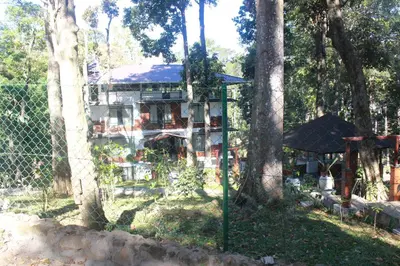 a house in the woods with a fence and trees at VANYA by Citrine in Nelliyampathy
