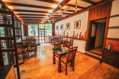 a dining room with tables and chairs in a room at VANYA by Citrine in Nelliyampathy