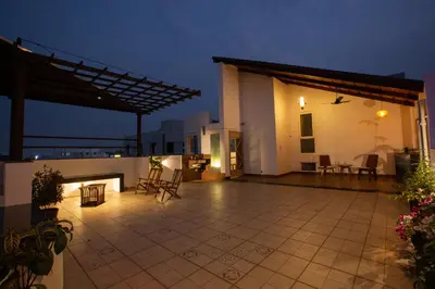 a patio with chairs and tables on a house at night at Sarvam Serviced Apartment in Coimbatore