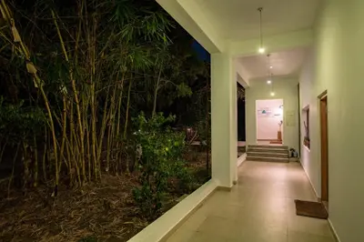 a hallway with a large wall of bamboo plants at Dhole's Den Bandipur in Bandipūr