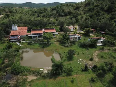 an aerial view of a house on a hill with a pond at Dhole's Den Bandipur in Bandipūr