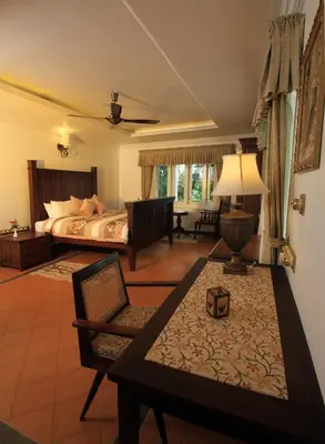 a bedroom with a bed and a living room at Parisons Plantation Experiences by Abad in Mananthavady