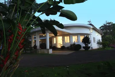 a large white house with the lights on at Parisons Plantation Experiences by Abad in Mananthavady