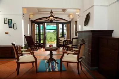 a living room with chairs and a fireplace at Parisons Plantation Experiences by Abad in Mananthavady