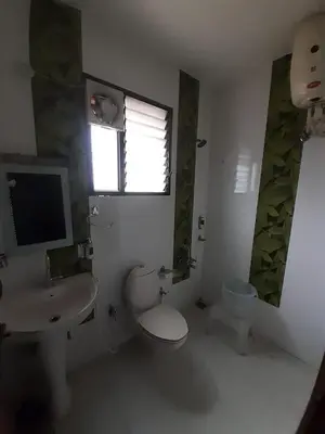 a bathroom with a toilet and a sink and a window at kurinji residency in Ooty