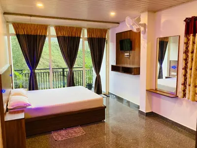 a bedroom with a bed and a balcony at CARMEL HOME STAY in Munnar