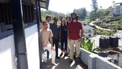 a group of people standing on the balcony of a house at CARMEL HOME STAY in Munnar