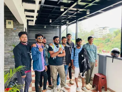 a group of men standing outside of a building at CARMEL HOME STAY in Munnar