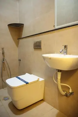 a bathroom with a toilet and a sink at Hotel Amoha in Palani