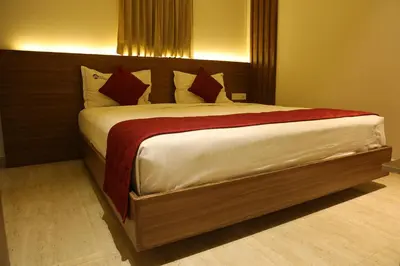 a bedroom with a large bed with red pillows at Hotel Amoha in Palani