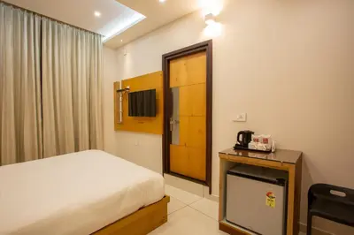 a hotel room with a bed and a television at Hasco Tower in Palakkad