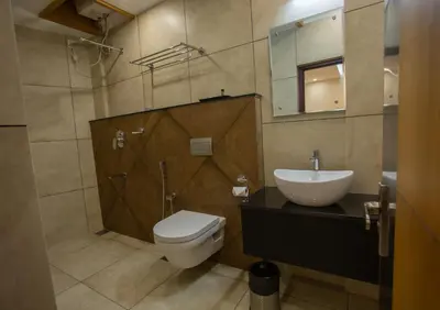 a bathroom with a toilet and a sink and a mirror at Hasco Tower in Palakkad