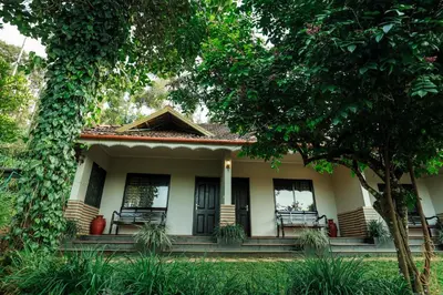 a small house with benches in the yard at Hill Rows Plantation and Forest Experience By GreenEscapes in Vythiri