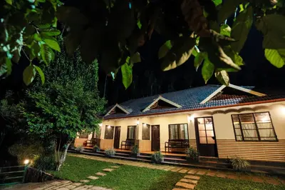 a house at night with lights at Hill Rows Plantation and Forest Experience By GreenEscapes in Vythiri