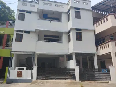 a white building with a gate in front of it at Yoga House in Vānivilāsa Puram