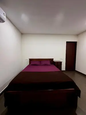 a bedroom with a bed with a purple blanket at Wayanad Cocos Villa in Tariyod