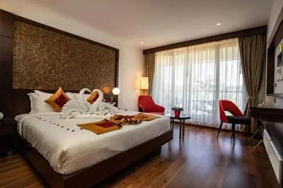 a hotel room with a large bed and a large window at Saugandhika West Gate in Wayanad