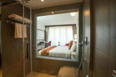 a hotel room with a bed and a glass door at Saugandhika West Gate in Wayanad