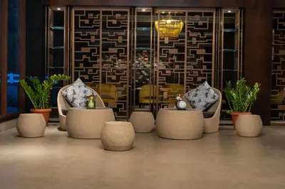 a lobby with a bunch of chairs and plants at Saugandhika West Gate in Wayanad