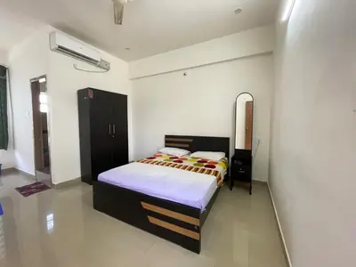 a bedroom with a bed and a mirror in it at Green Valley Residency in Gundlupet
