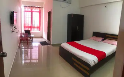 a bedroom with a bed with a red and white blanket at Green Valley Residency in Gundlupet
