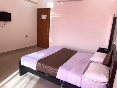 a bedroom with a bed and a television in it at Green Valley Residency in Gundlupet